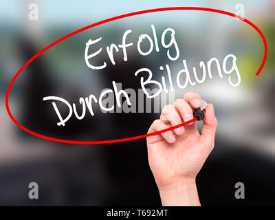 Mann Hand schreiben Erfolg durch Bildung (Erfolg durch die Ausbildung in Deutsch) mit schwarzem Marker auf visuelle Bildschirm. Stockfoto