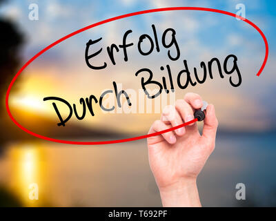 Mann Hand schreiben Erfolg durch Bildung (Erfolg durch die Ausbildung in Deutsch) mit schwarzem Marker auf visuelle Bildschirm. Stockfoto