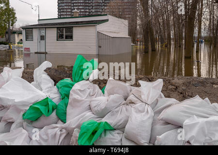 Pierrefonds-Roxboro, Quebec, Kanada - 29 April 2019: Haus durch Wasser im Frühjahr Hochwasser überschwemmt, mit Sandsäcken in der foregroung. Stockfoto