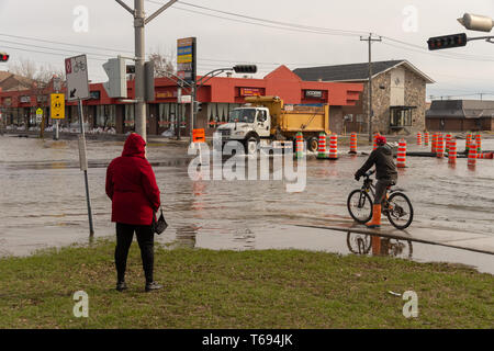 Pierrefonds-Roxboro, Quebec, Kanada - 29 April 2019: Menschen in einem versunkenen Straße im Frühjahr Hochwasser Stockfoto