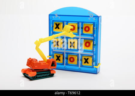 Tic Tac Toe und Spielzeug Earthmover auf weißem Hintergrund Stockfoto