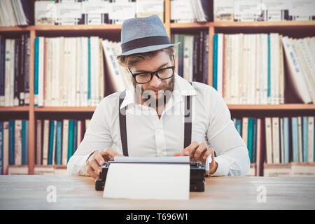 Zusammengesetztes Bild Hipster trägt Brille und Hut auf Schreibmaschine arbeiten Stockfoto