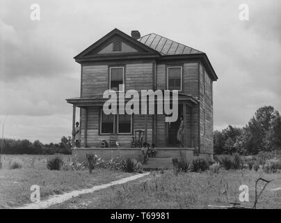 Schwarz-weiß Foto von mehreren Kindern, Sitzen und Stehen auf der Veranda eines verwitterten, Holz- Haus in Caroline County, Virginia, USA; von Jack delano fotografiert, unter der Schirmherrschaft von Farm Security Administration der Vereinigten Staaten, Juni, 1941. Von der New York Public Library. () Stockfoto