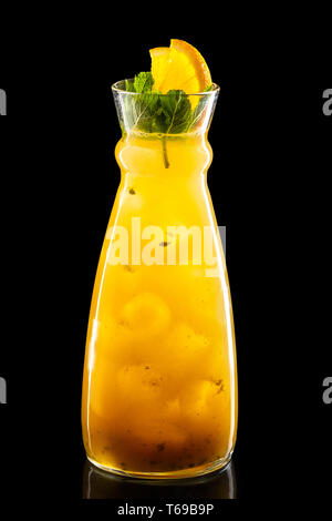 Krug mit Orange und Passion fruit ice Limonade auf schwarzem Hintergrund Stockfoto