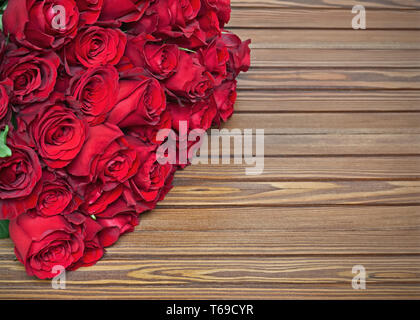 Bunter Blumenstrauß aus roten Rosen auf Holz- Hintergrund. Stockfoto