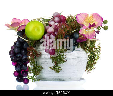 Zusammensetzung von künstlichen Blumen und Früchten. Stockfoto