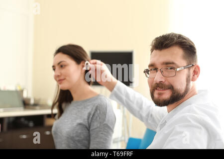 Otolaryngologist das Hörgerät im Ohr der Frau im Innenbereich Stockfoto