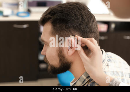 Otolaryngologist das Hörgerät im Ohr des Menschen im Krankenhaus Stockfoto