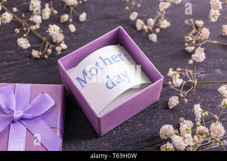 Karte mit dem Satz "Tag des Anderen" in Geschenkbox und Blumen auf dem Tisch Stockfoto