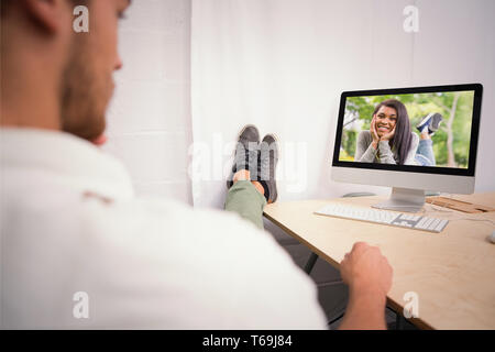 Zusammengesetztes Bild der Geschäftsmann mit Beinen überquerte am Knöchel am Schreibtisch Stockfoto