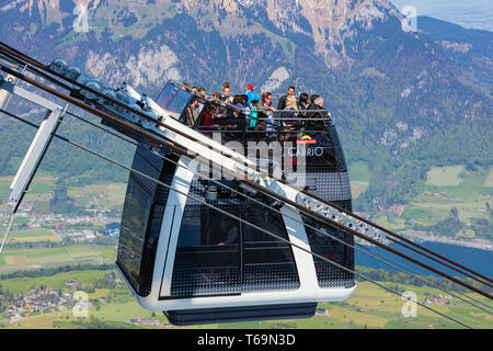 Mt. Stanserhorn, Schweiz - 7. Mai 2016: Menschen in einer Gondel des Stanserhorn Cabrio Overhead Seilbahn verlassen Sie den Bahnhof auf der Oberseite des Mou Stockfoto