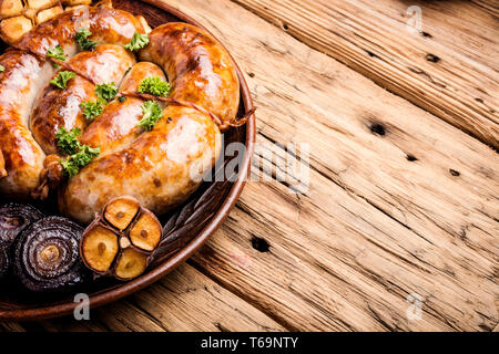 Gegrillte Würstchen auf Holzbrett. Würstchen gebraten mit Gewürzen Stockfoto