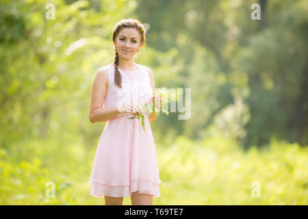 Porträt eines jungen Mädchens, das auf einer Wiese Blumen pflücken Stockfoto