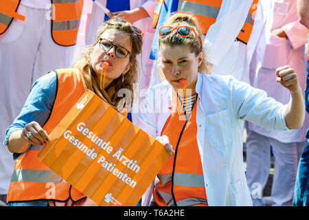 Oldenburg, Deutschland. 30 Apr, 2019. Zwei Ärzte aus der kommunalen Krankenhäuser in Niedersachsen stehen vor dem Oldenburger Klinik bei einem Warnstreik mit einem Karton Schild "Gesund Arzt - gesunde Patienten. Die medizinische Organisation Marburger Bund hat für den Warnstreik aufgerufen. Credit: mohssen Assanimoghaddam/dpa/Alamy leben Nachrichten Stockfoto