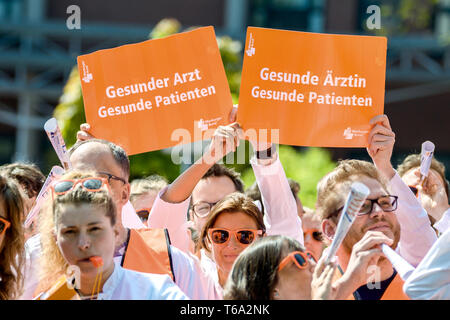 Oldenburg, Deutschland. 30 Apr, 2019. Zwei Ärzte aus der kommunalen Krankenhäuser in Niedersachsen stehen vor dem Oldenburger Klinik bei einem Warnstreik mit einem Karton Schild "Gesund Arzt - gesunde Patienten. Die medizinische Organisation Marburger Bund hat für den Warnstreik aufgerufen. Credit: mohssen Assanimoghaddam/dpa/Alamy leben Nachrichten Stockfoto