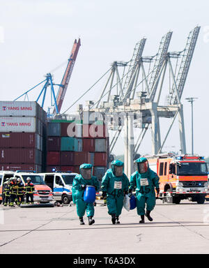 Hamburg, Deutschland. 30 Apr, 2019. Feuerwehrmänner in Chemikalienschutzanzüge gehen durch den Hafen während einer Übung. Weil Hamburg profitiert auch von EU-Beihilfen, zum Beispiel in einem Projekt zu schweren Unfällen und Notfällen in großen Seehäfen zu verhindern, den Senat wirbt für ein starkes Europa vor den Wahlen zum Europäischen Parlament. Die Gefahrgut übung nahm daher im Rahmen der Europäischen Woche. (Z dpa' Hamburger Senat fördert ein starkes Europa mit Europawoche") Credit: Daniel Bockwoldt/dpa/Alamy leben Nachrichten Stockfoto