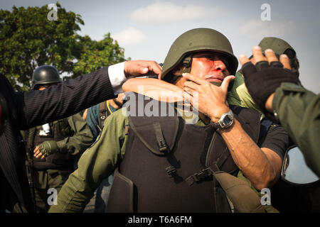 Caracas, Venezuela. 30 Apr, 2019. Die Gegner von Venezuelas Präsident Maduro (zurück) mit einem Offizier der Bolivarischen National Guard loyal gegenüber dem Staatsoberhaupt ringen. Die Venezolanische Opposition leader Guaido und inhaftierten Oppositionsführer Lopez rief die Soldaten und die Bevölkerung auf die Straßen, um gegen die Regierung zu übernehmen. Credit: Ruben Sevilla Marke/dpa/Alamy leben Nachrichten Stockfoto