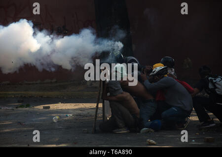 Caracas, Venezuela. 30 Apr, 2019. Demonstranten Zusammentreffen mit venezolanische Sicherheitskräfte. Die Venezolanische Opposition leader Guaido und inhaftierten Oppositionsführer Lopez rief die Soldaten und die Bevölkerung auf die Straßen, um gegen die Regierung zu übernehmen. Credit: Ruben Sevilla Marke/dpa/Alamy leben Nachrichten Stockfoto