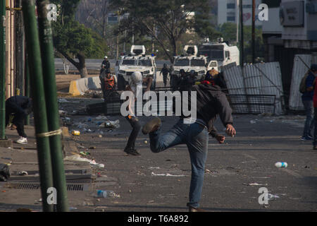 Caracas, Venezuela. 30 Apr, 2019. Die Demonstranten werfen Molotowcocktails auf die venezolanische Sicherheitskräfte. Die Venezolanische Opposition leader Guaido und inhaftierten Oppositionsführer Lopez rief die Soldaten und die Bevölkerung auf die Straßen, um gegen die Regierung zu übernehmen. Credit: Ruben Sevilla Marke/dpa/Alamy leben Nachrichten Stockfoto