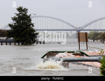 Davenport, Iowa, USA. 30 Apr, 2019. Eine Pumpe sendet Wasser über die hesco Barrieren an River Drive in Davenport, Iowa, Dienstag, 30. April 2019. Credit: Kevin E. Schmidt/Viererkabel - Zeiten/ZUMA Draht/Alamy leben Nachrichten Stockfoto