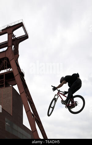 Jumping BMX rider vor kopfbedeckungen der Zeche Zollverein, Essen, Ruhrgebiet, Deutschland, Europa Stockfoto