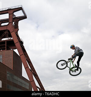 Jumping BMX rider vor kopfbedeckungen der Zeche Zollverein, Essen, Ruhrgebiet, Deutschland, Europa Stockfoto