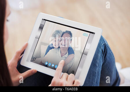 Zusammengesetztes Bild Teen mit einem Tablet-pc auf dem Boden sitzend Stockfoto