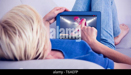 Zusammengesetztes Bild blonde Frau mit ihrem Tablet auf der couch Stockfoto