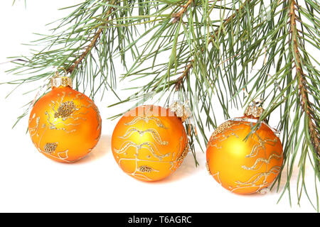 Weihnachtsbaum und Drei goldene Weihnachtskugeln. Auf weiß Isoliert Stockfoto