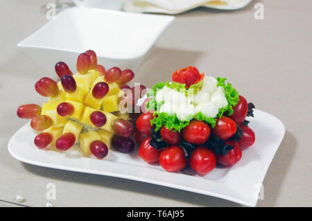 Frische Weintrauben, Kirschen und Käse Decotating auf einem Teller Stockfoto