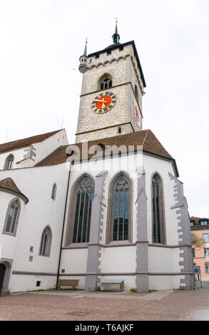 Schaffhausen, SH, Schweiz - 22 April 2019: Der kirchhofplatz Square mit den Menschen und der Kirche Sankt Johann Stockfoto