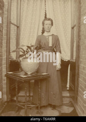 Edwardian Postkarte von Frau außer Haus mit Aspidistra Haus Pflanze im Topf, in Großbritannien um 1910 Stockfoto