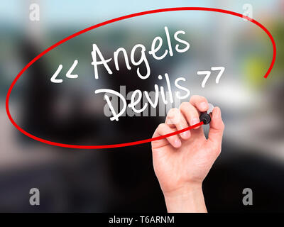 Mann Hand schreiben Engel - Teufel mit schwarzem Marker auf visuelle Bildschirm. Stockfoto