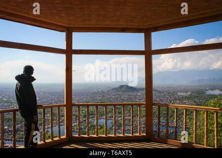 Eine Person mit einem Luftbild der Innenstadt von Srinagar Stadt und Hausboote in Dal Lake von einem Aussichtspunkt auf Shankracharya Hill Stockfoto