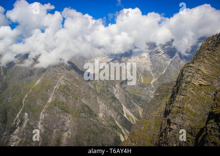 Niedrige Wolken, Stratus Wolken direkt über dem hoch aufragenden Berge des Himalaja in Kaschmir mit tief blauen Himmel Stockfoto