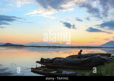 Einen wunderschönen Sonnenuntergang auf dem Dal Lake in Kaschmir. Boote der Fischer geparkt am Ufer des Sees Stockfoto