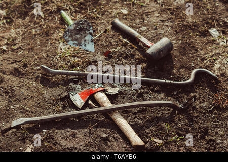 Garten Werkzeuge ax und Brecheisen liegen auf dem Boden Stockfoto
