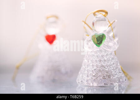 Zwei kleine Glas Engel Statuetten mit Herzen in ihren Händen. Das Konzept der Frieden, Güte und Liebe. Engel immer in der Nähe von uns. Stockfoto