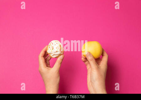 Die richtige Ernährung. Weibliche Hände halten einen Kuchen und Messen grünes Band. Diät. Schlanke Menschen. Stockfoto