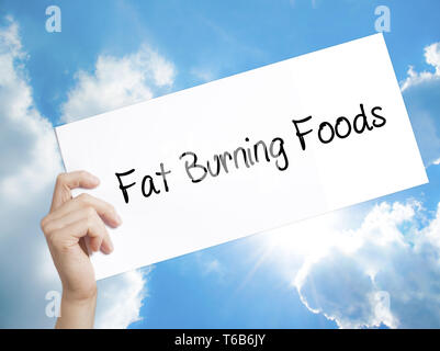 Fat Burning Foods Zeichen auf weißem Papier. Mann Hand, Papier mit Text. Auf Himmel Hintergrund isoliert Stockfoto