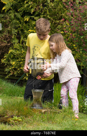 Junge Kinder, Bruder und Schwester, Teich zusammen tauchen, mit Net, Garten Tiere Teich, älterer Bruder, jüngere Schwester, die gemeinsam spielen. Natur, Stockfoto