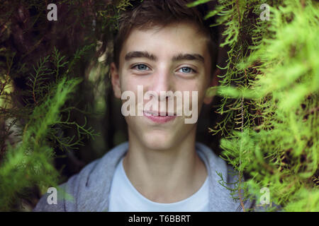 Porträt eines jungen Mannes stehen unter einem Baum Stockfoto