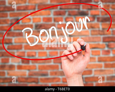 Mann Hand schreiben Bonjour (Guten Morgen in französischer Sprache) mit schwarzem Marker auf visuelle Bildschirm Stockfoto