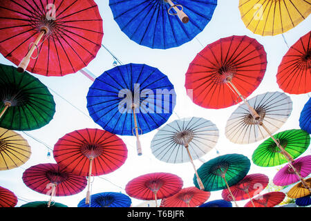 Sonnenschirme hängen mit den bunten auf Sky in Thailand. Stockfoto