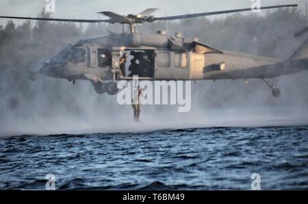 190416-N-TC 182-3048 NAVAL BASE GUAM (15. April 2019) Segler für die Beseitigung von Explosivstoffen Mobile Einheit (EODMU) 5, aus einem MH-60S Seahawk Hubschrauber springen zugeordnet, Hubschrauber Meer Combat Squadron (HSC) 25, während einer Besetzung und Recovery teil der Naval Helicopter Seilaufhängung Technik (HRST) Kurs. EODMU-5 ist zum Kommandanten, Marine Expeditionary Forces Pacific, die primäre Expeditionary task force verantwortlich für die Planung und Ausführung der Küstengebiete Riverine operations, Beseitigung von Explosivstoffen, tauchen Engineering und Bau zugeordnet und Unterwasser Bau in der Stockfoto