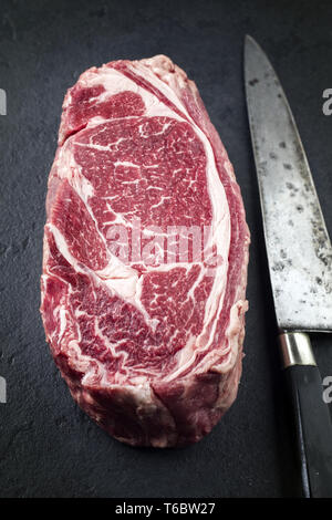 Raw trockenen Jahren Wagyu Rib Eye Steak mit Messer auf einem Schiefer Stockfoto