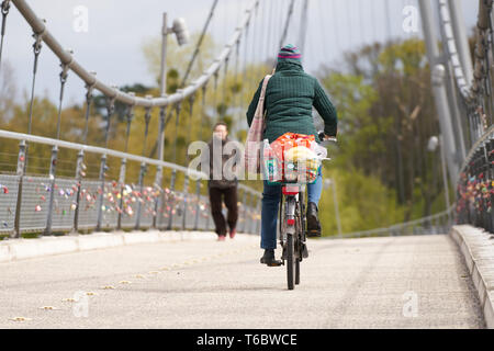 Radfahrer und Fußgänger auf einer Hängebrücke in Magdeburg. Stockfoto