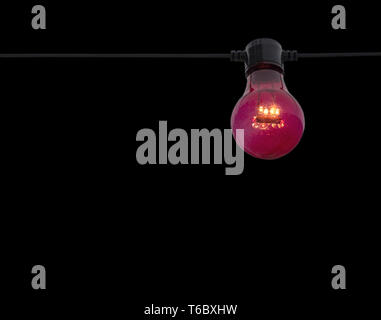 Rote Farbe Glühbirne auf String isoliert auf Schwarz Stockfoto