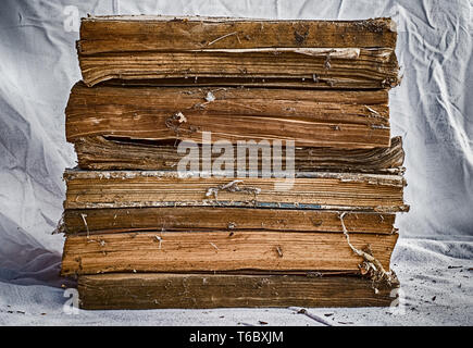 Alte Bücher auf schmutzigen weißen Tuch gestapelt Stockfoto