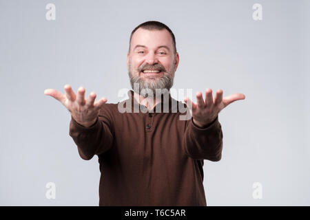 Erfolg positive Emotionen. Gerne reifer Mann mit Bart stretching Hände vor Stockfoto